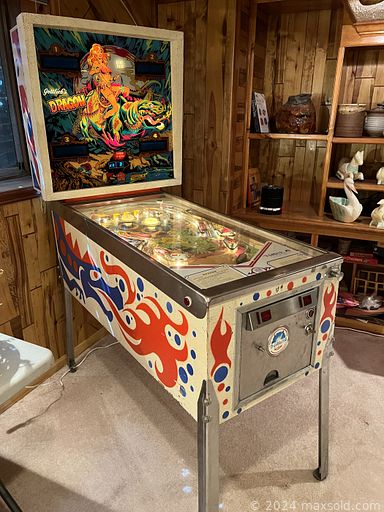 MaxSold Auction: This online auction features Gottlieb\'s Dragon pinball machine, Wurlitzer Spinet piano, signed artwork, brass decor, furniture such as side tables, vintage chairs, vintage modular couch, and dining table with chairs, area rugs, holiday decor, lamps, political memorabilia, gardening supplies, home health aids, Bruno stair lift and much more!
