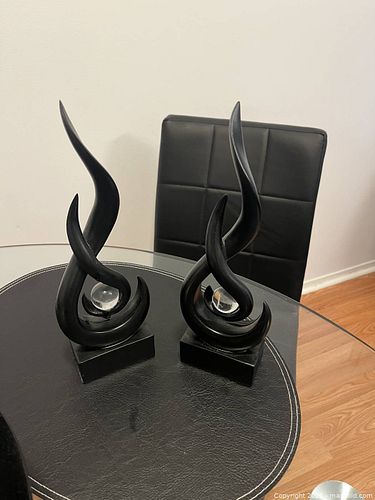 Elegant pair of black abstract sculptures. Each sculpture has a flowing, curved design (1 of 1)