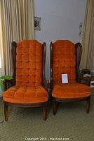 Pair of vintage chairs with wood frames and orange tufted upholstery, front view