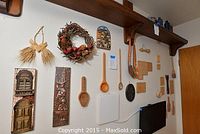 Wide view of wall displaying the collection of German wooden spoons, cookie molds, plaques, and wreath.