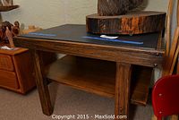 Front-side view of the wood table showing the rectangular top, thick legs, and the lower shelf.