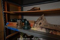 Shelf with assorted glass insulators in cardboard box
