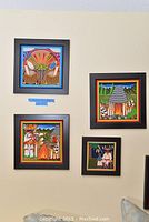 Four framed Huichol yarn paintings arranged on a wall, showing detailed colorful yarn art with black frames.