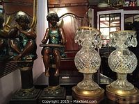 Angels next to lamps seen together, showing size and color contrast.