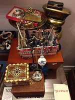 Overall view of boxes, jewelry and brass items on table
