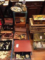 Overview of all jewelry boxes and assorted costume jewelry pieces arranged on floor