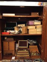 Full view of wooden cabinet shelf holding all storage boxes and jewelry items