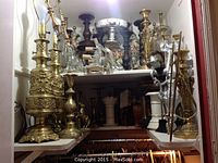 Two ornate brass table lamps and assorted items on upper shelf