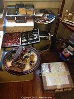 Overall view of trays and table showing trays of cufflinks, sunglasses and miscellaneous accessories