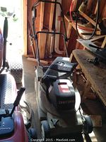 Full view of Craftsman electric lawn mower with the handle and body visible in storage area.