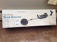 Photo of the metal detector's original box showing the model and product image with the box worn at the edges.
