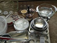 Overview of kitchen items laid on carpet: glass canisters, condiment set, Pyrex measuring cup, baking dishes and bowls.
