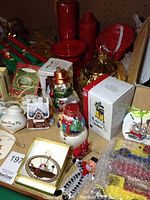 Photo showing various Christmas ornaments including snowmen, boxed ornaments, red candles, and candy bowls.