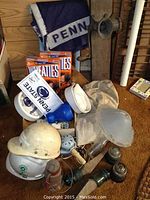 Full lot showing Hemingray glass insulators, Penn State memorabilia including Wheaties boxes and seat pads, old meat grinder, and other items.