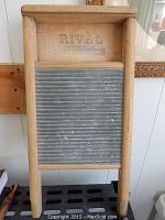 Full front view of the wooden framed washboard with metal scrubbing surface and faint logo stamp above.