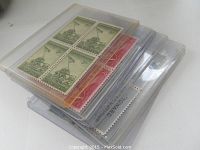 Stack of protective plastic sleeves containing multiple stamp blocks and lots from the 1950s collection