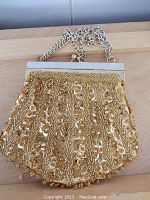 Front view of vintage woman's small purse showing detailed gold bead and sequin embellishments with a silver-tone chain strap and mother of pearl frame top.