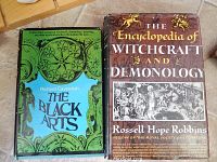 Photo showing front covers of both books, 'The Black Arts' with a green cover and 'The Encyclopedia of Witchcraft and Demonology' with a brown cover.