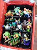 Top view of the black compartmentalized case containing 19 varied Teenage Mutant Ninja Turtles action figures, showing turtles in different poses, colors, and costumes.