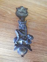 Showing the full view of the miniature metal door knocker with pixie/elf figure and floral top mount.