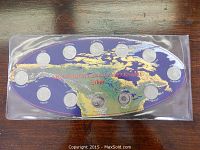 Full set of 12 Canadian Millennium 2000 coins in protective pouch on a wooden surface, showing background map of Canada and red text.