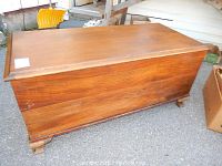 Front angle view of cedar chest blanket box showing wood grain and carved feet