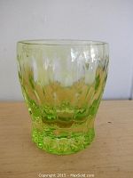 Front view of green cut glass toothpick holder showing intricate texture and shape.