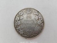 Close-up front side of the 1918 Canadian 50 cent coin showing denomination, date, crown, and maple leaf wreath design.