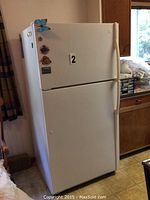 Exterior view of closed top-freezer refrigerator with magnets on the door