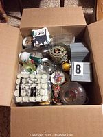Top-down view of box containing assorted small items including glass offcuts and supplies