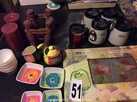 Photo showing all items including candles, sauce dishes, travel mugs, and figurine candle holder arranged together.