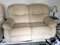 Front view of beige corduroy reclining loveseat in upright position