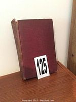 Front cover of hardcover book with reddish-brown cloth, showing some wear and frayed edges.