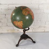 Front view of the terrestrial globe showing continents and ocean patterns with visible dents.