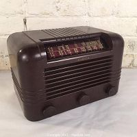 Front angled view of RCA Victor Model 5610 Bakelite radio showing horizontal grille, control knobs and tuning dial.