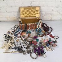 Overview of the vintage estate jewelry displayed in and around an old wicker sewing basket with satin interior lining.