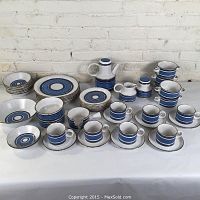 Full set arranged on table showing all items including plates, cups, saucers, bowls, coffee pot, creamer, and sugar.