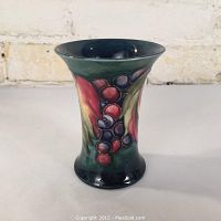 Front view of vase showing leaf and berry relief design