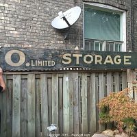 Full view of the entire wooden sign hung on fence