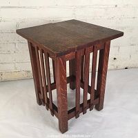 Front view of antique Arts and Crafts oak side table showing square top and slatted vertical side design.