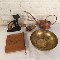 Full lot overview showing all five metal antique items on a white surface against brick wall.