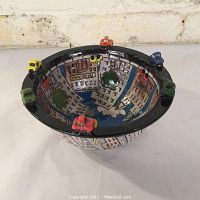 Angled view of the bowl showing the painted cityscape interior and small cars attached to the rim