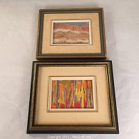 Two framed oil on board paintings with fall themes, one with abstract vertical tree forms in bright fall colors, the other a muted fall landscape with trees and sky