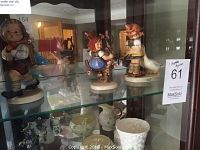 Three figurines displayed side by side on shelf