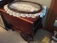 Full view of tea cart with removable tray and lace doily on top