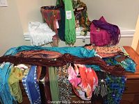 Wide view of most scarves spread out, showing a range of colors and patterns including blue, white, pink, red, and multicolored.