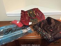 Overview of the Fendi style purse alongside three scarves on wooden surface.