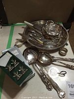Full view of most items laid out on table showing large tray, smaller bowl, knives, napkin rings and boxed napkin holders