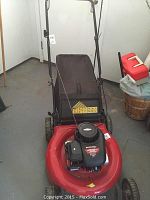 Front view of Yardworks gas lawn mower with grass collection bag and control handle.