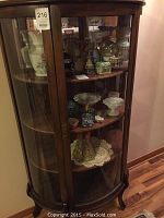 Front view of wooden curio cabinet displaying shelves and glass doors